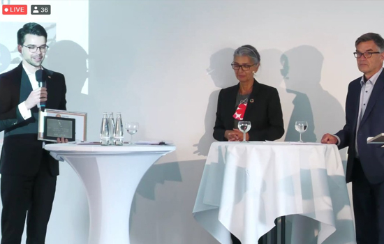 Foto: Adrian Malzer bei der Übergabe, Paula Land und Dr. Ulf Jaeckel am Podium