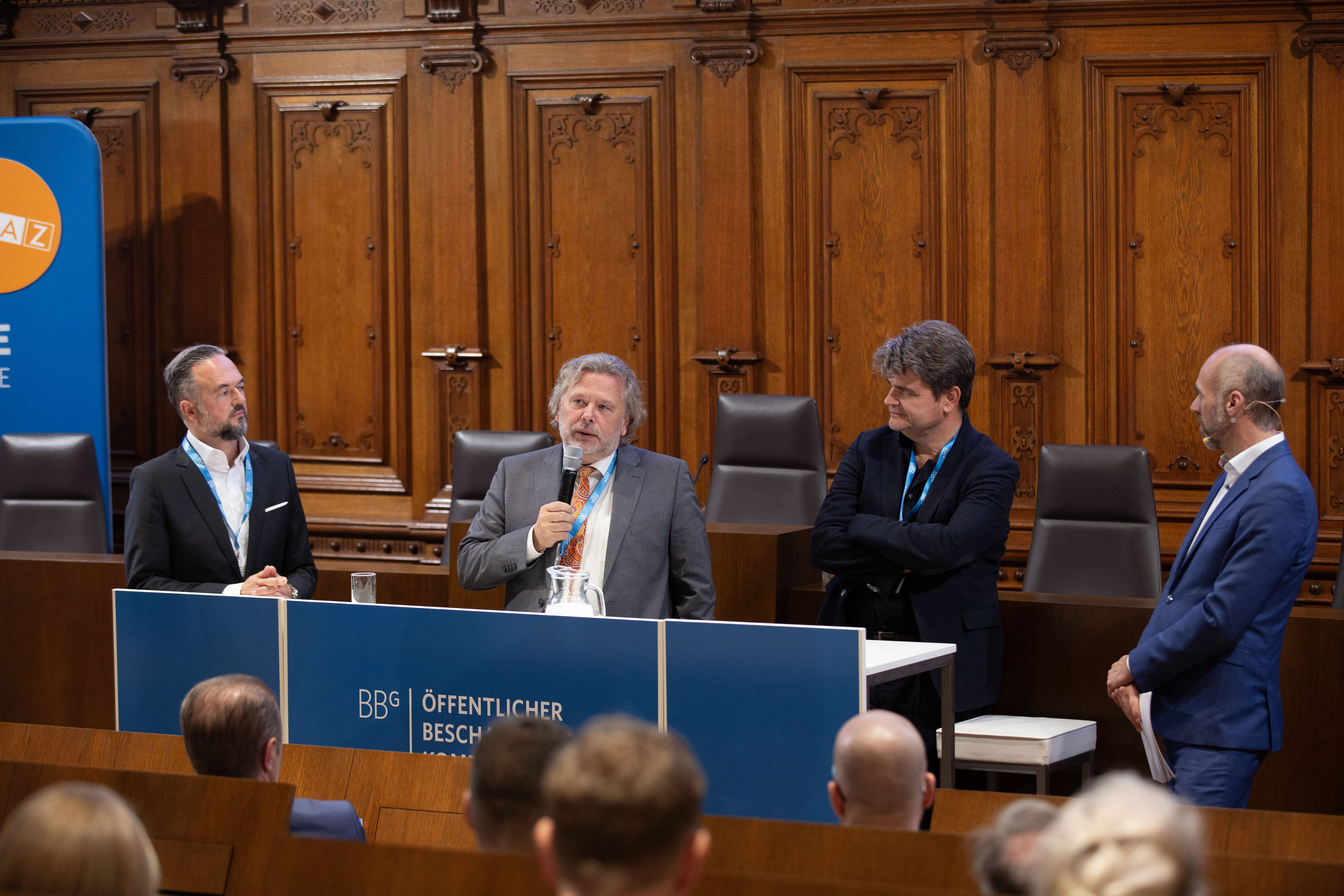 Der Moderator und einige Speaker am Podium 