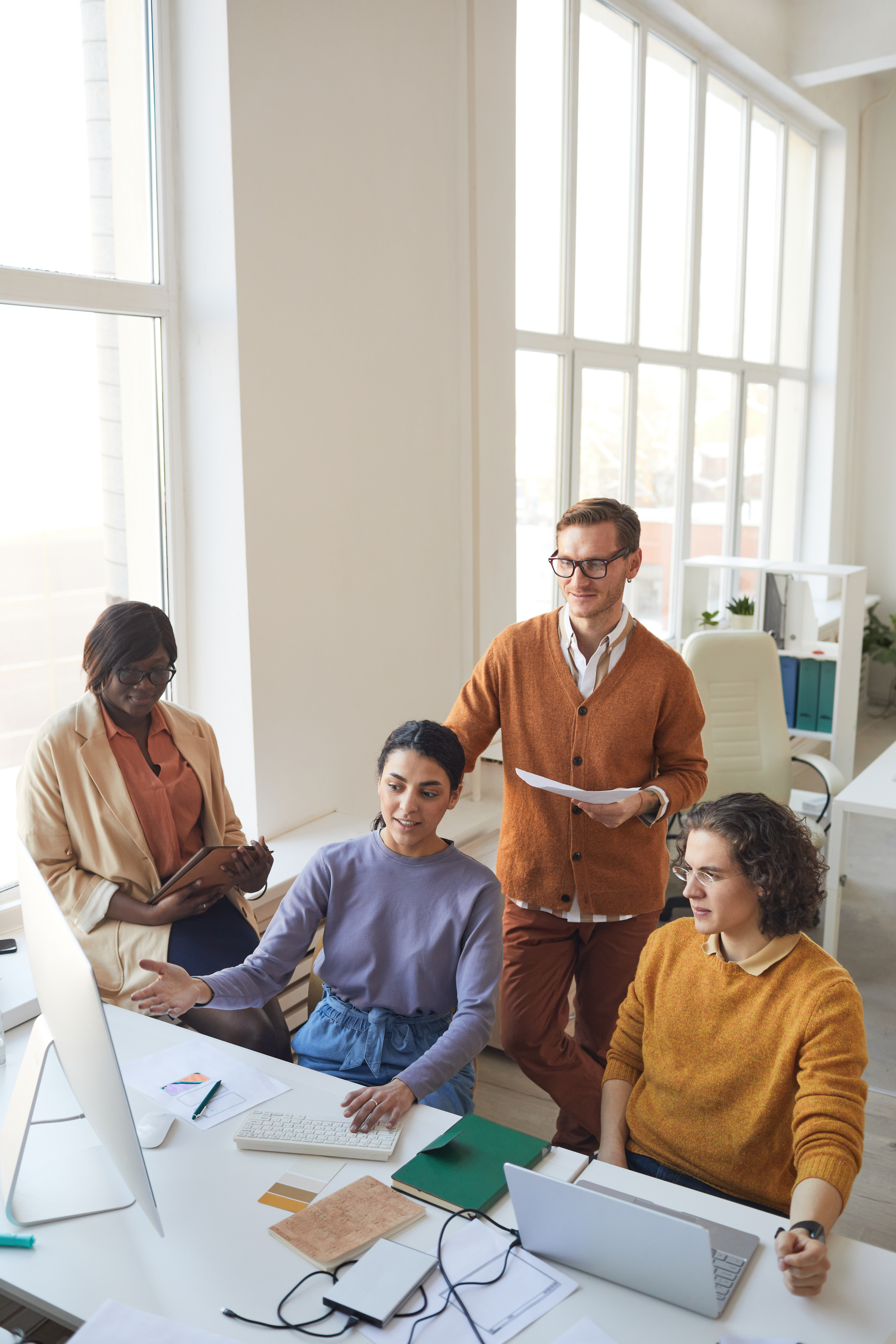 Ein Team sitzt an einem Schreibtisch und bespricht ein Projekt