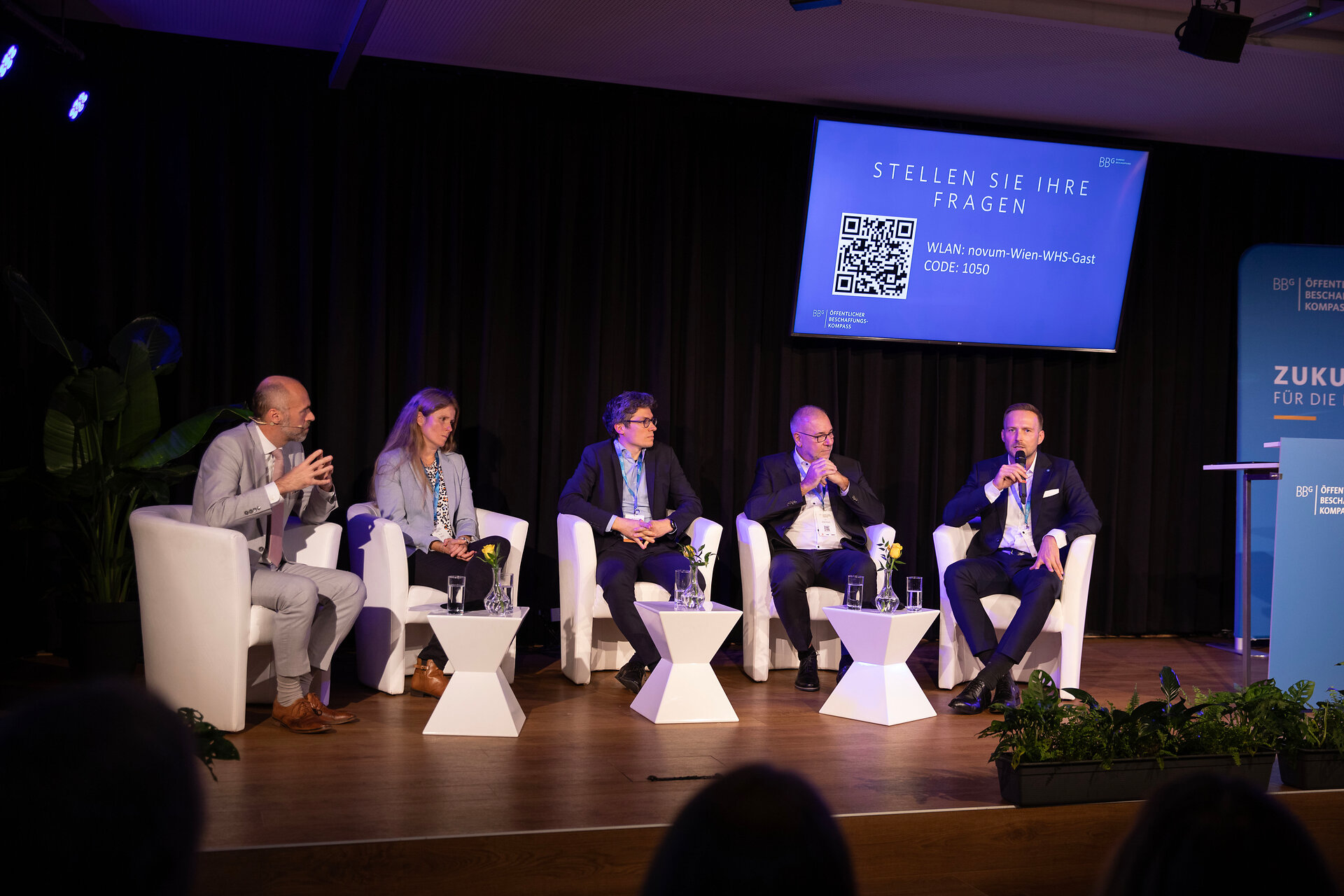 Die Moderatorin und einige Speaker bei der Podiumsdiskussion auf der Bühne