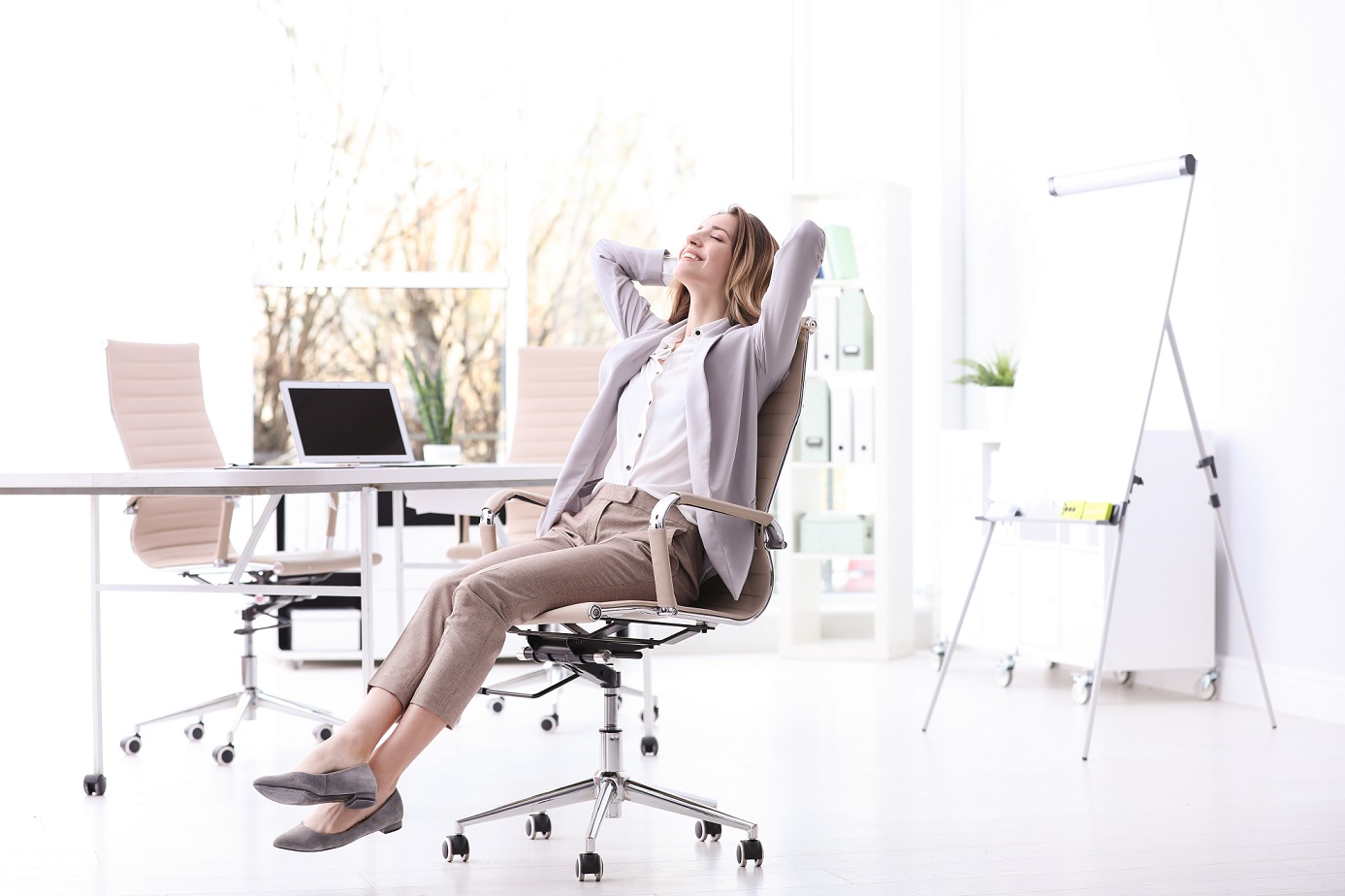Frau sitzt im Büro auf einem Bürostuhl