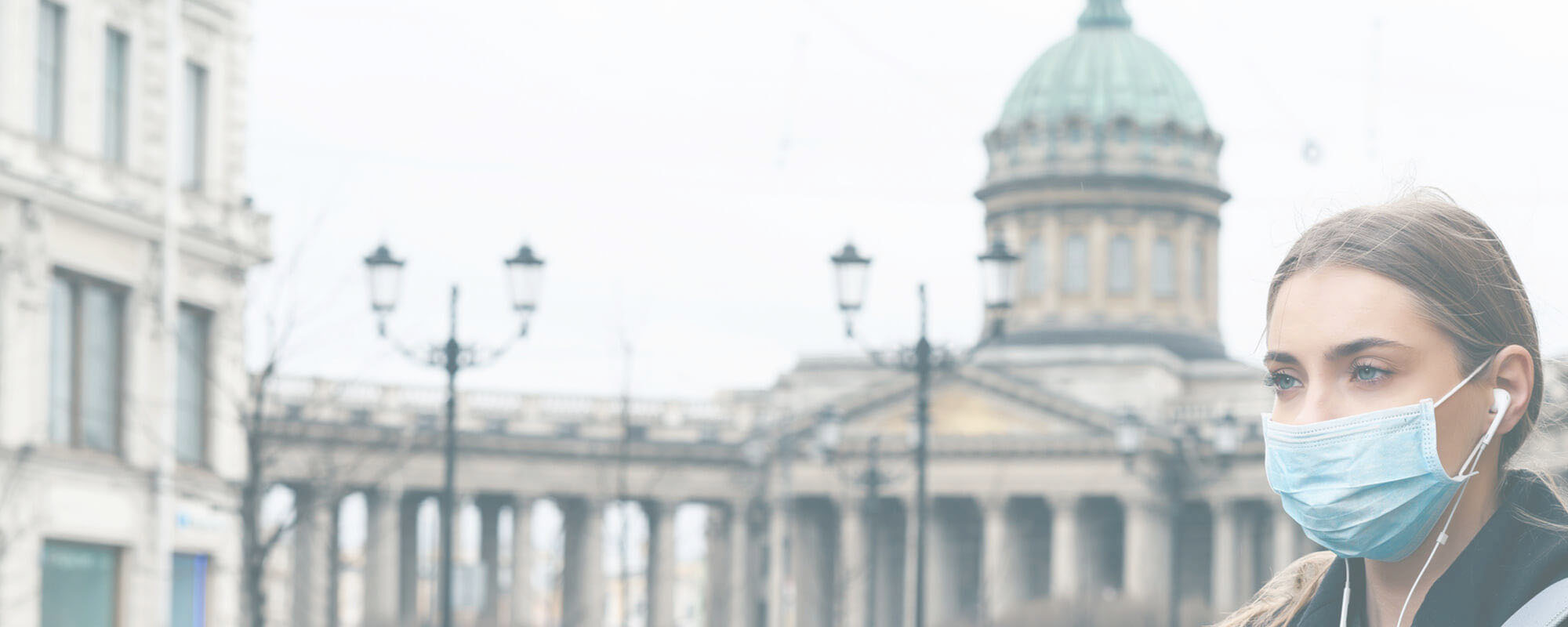Foto: Frau trägt eine Schutzmaske vor einem öffentlichen Gebäude