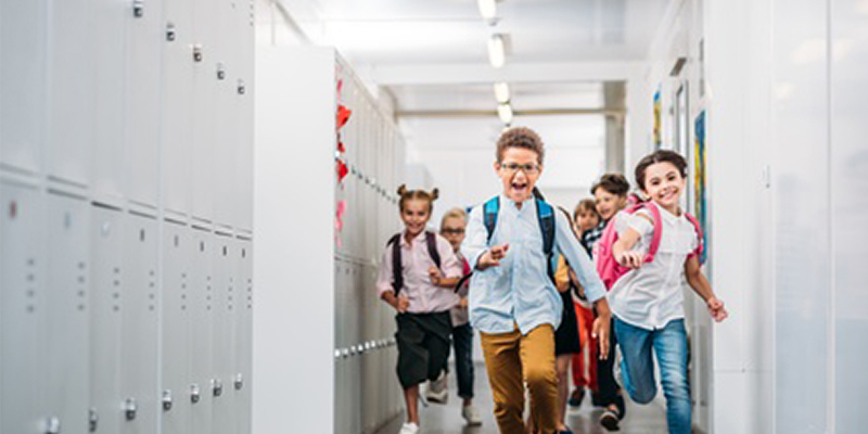 Schüler laufen durch einen Gang mit Gaderoben