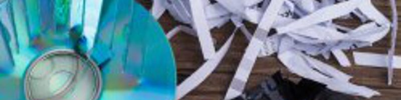 Kaputte CDs und geschreddertes Papier liegen auf einer Fläche 