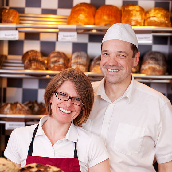 Foto: Bäcker und Bäckerin vor einem Verkaufsregal