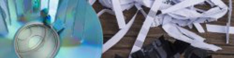 Kaputte CDs und geschreddertes Papier liegen auf einer Fläche 