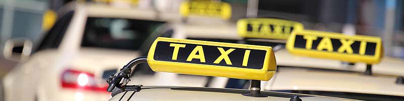 Foto: Taxi-Schilder auf meherern weißen Autos