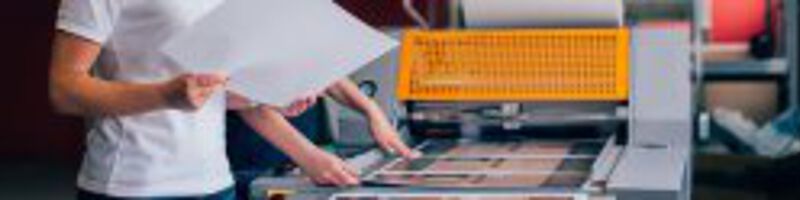 Druck_Drucksorten_Druckerei_Fotolia_156018975_S Zwei Menschen drucken Bilder bei einem Drucker