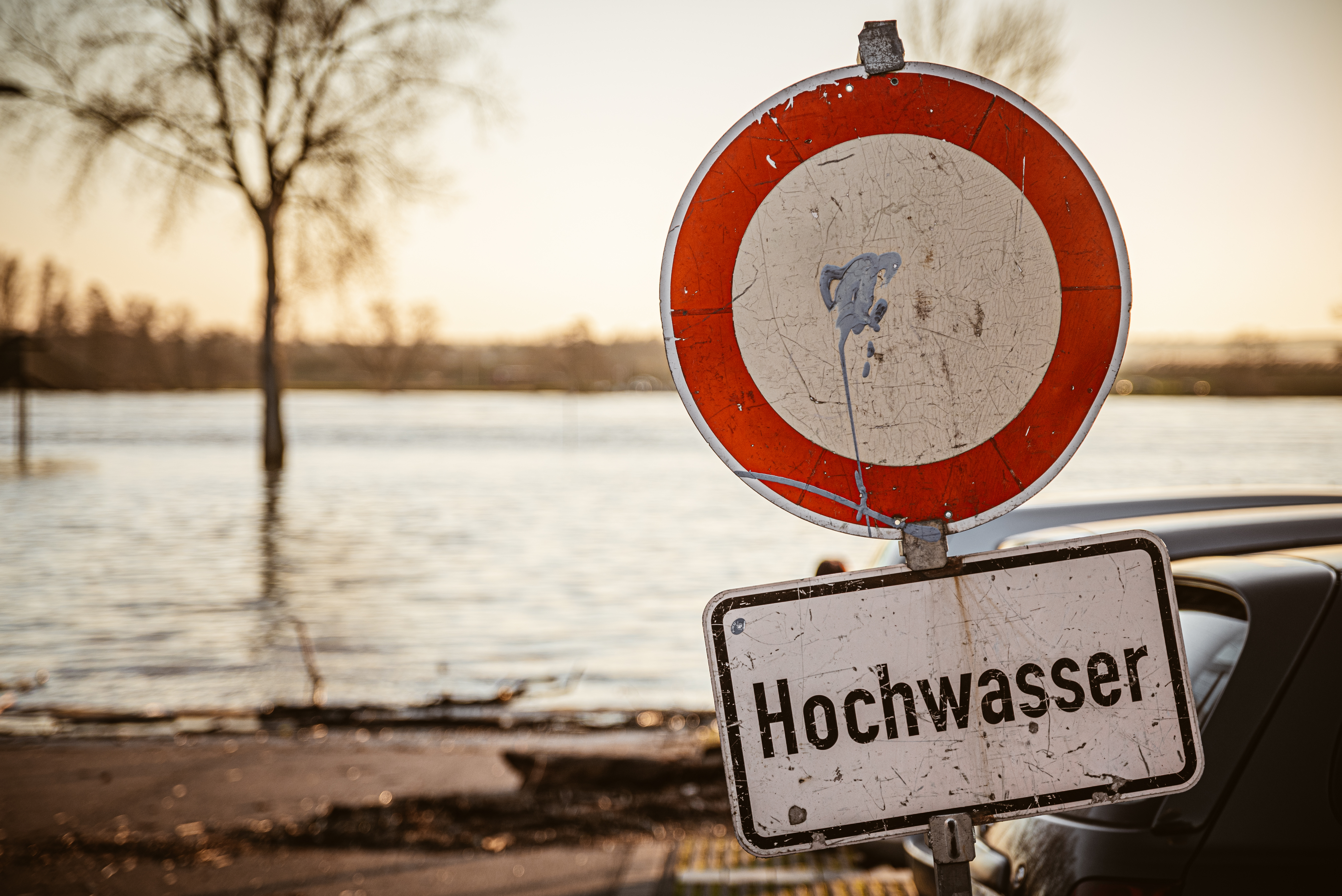 Hochwasser_AdobeStock_321528897 Foto: Überschwemmtes Gebiet mit Schild "Achtung Hochwasser"